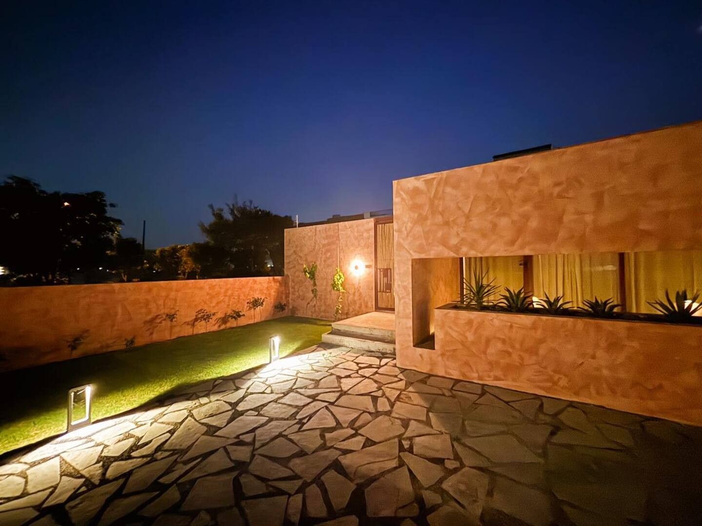Apricot Garden Courtyard — stone path and lit walls at dusk
